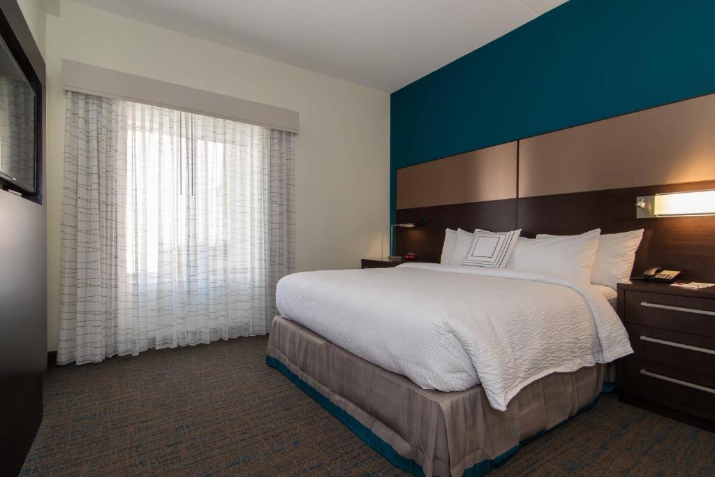 罗利罗利达勒姆机场/布莱尔克里克原住客栈的一间卧室设有一张大床和蓝色的墙壁