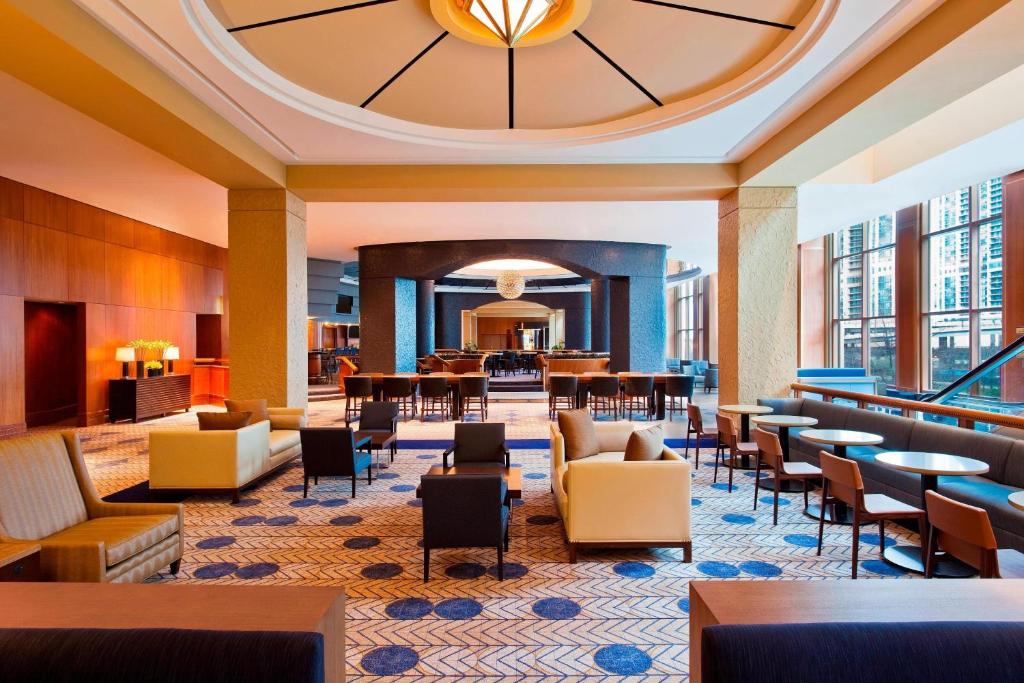 芝加哥Sheraton Grand Chicago Riverwalk的酒店大堂设有桌椅和餐厅