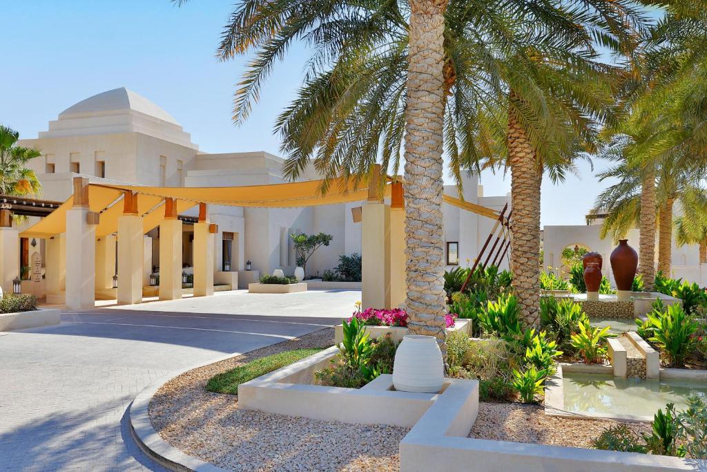 阿布扎比Al Wathba, a Luxury Collection Desert Resort & Spa, Abu Dhabi的棕榈树庭院和建筑