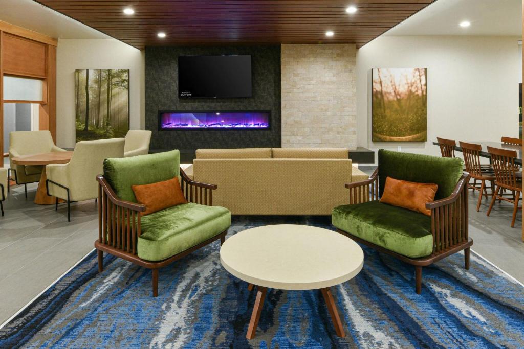 MoorparkFairfield Inn & Suites by Marriott Moorpark Ventura County的一间设有桌椅和电视的等候室