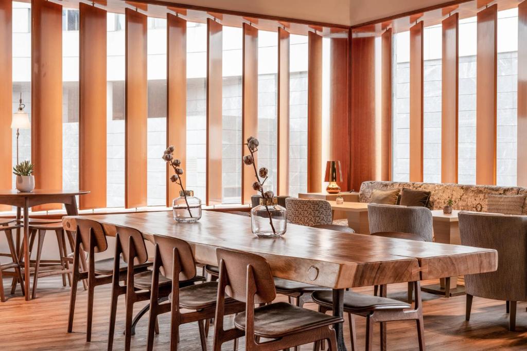 拉科鲁尼亚AC Hotel A Coruña by Marriott的一间带木桌和椅子的用餐室