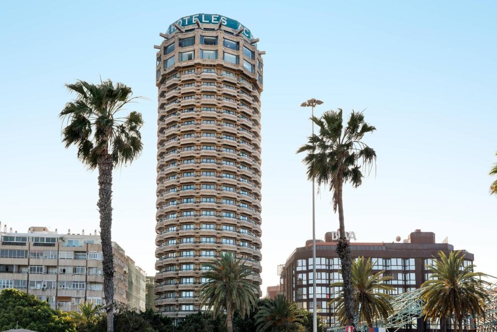 大加那利岛拉斯帕尔马斯大加那利万豪AC酒店的一座高大的建筑,前面有棕榈树