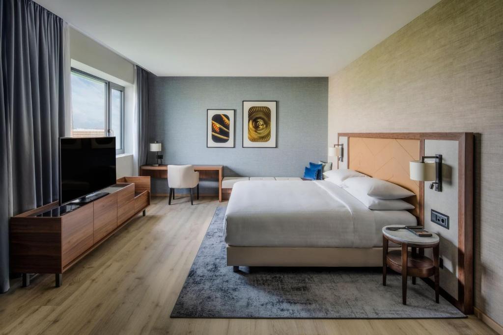 日内瓦Geneva Marriott Hotel的酒店客房,配有床和电视