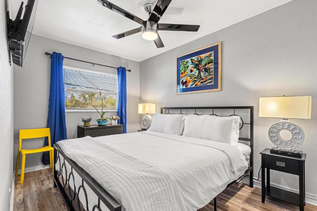 圣徒皮特海滩Sunset Beach Suites的一间卧室配有一张床和一张黄色椅子