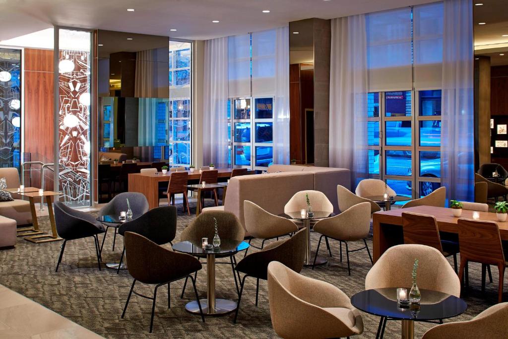波特兰AC Hotel by Marriott Portland Downtown, OR的餐厅设有桌椅和窗户。