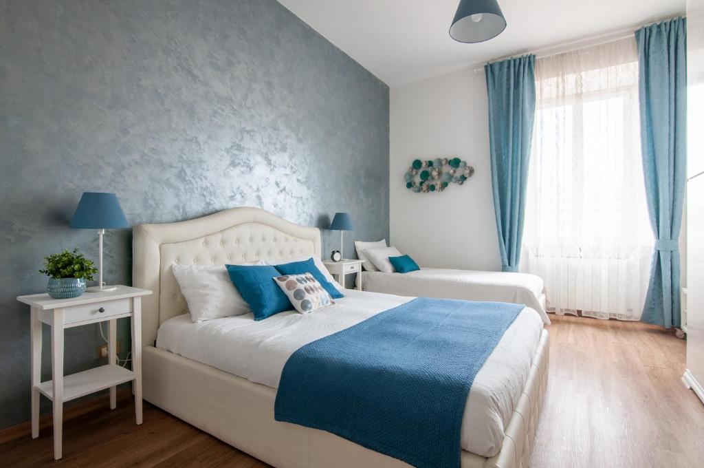 罗马泰尔米尼公寓的一间卧室配有两张蓝色和白色的床