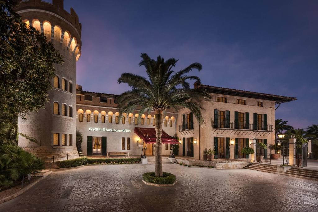 马略卡岛帕尔马Castillo Hotel Son Vida, a Luxury Collection Hotel, Mallorca - Adults Only的前面有棕榈树的建筑