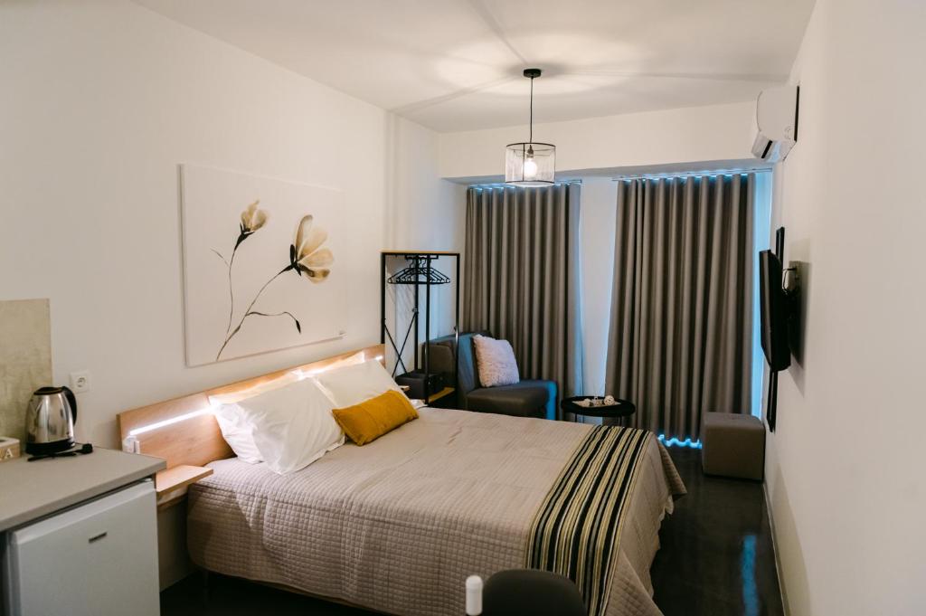 纳弗帕克托斯MAGNOLIA SUITES的卧室配有床、椅子和窗户。