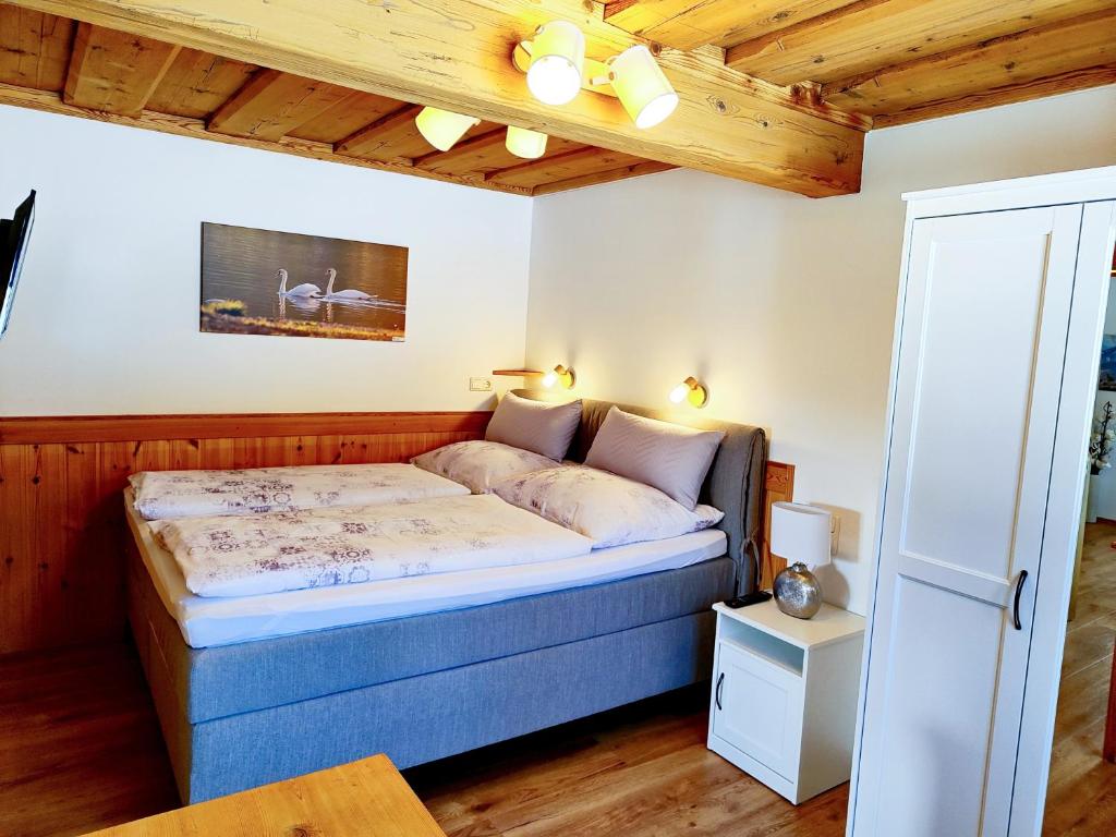 格伦德尔湖Ferienwohnung Grundlsee, Willkommen in MaMi's Ferienwohnung的一间带一张床的卧室,位于带木制天花板的房间内