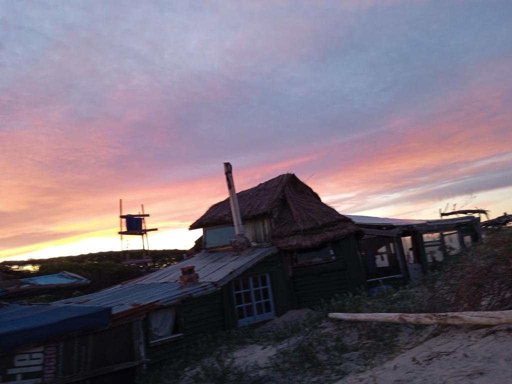 巴拉德瓦利扎斯Para un poquito relax的海滩上的房子,背景是日落