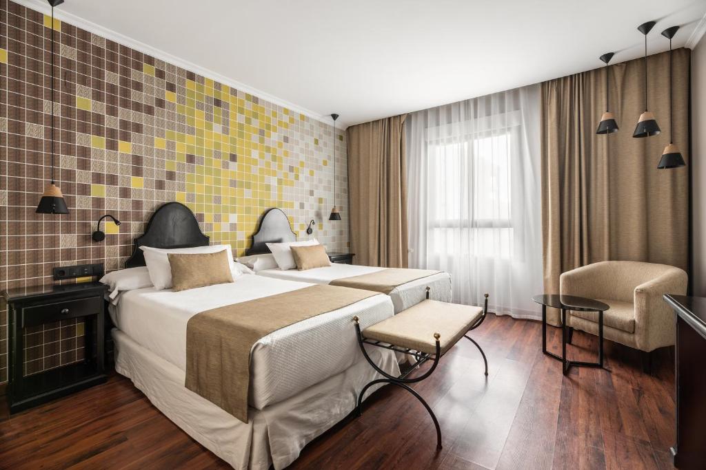 巴达霍斯Hotel Rio Badajoz的酒店客房带一张大床和一把椅子
