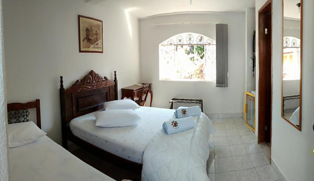 尤西德福拉门多萨旅馆的一间卧室设有两张床和窗户。
