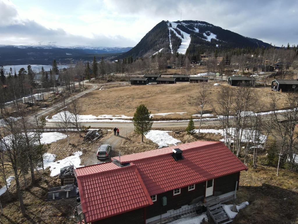 菲奈斯达伦Stuga , Funäsdalen的山前有红色屋顶的房子