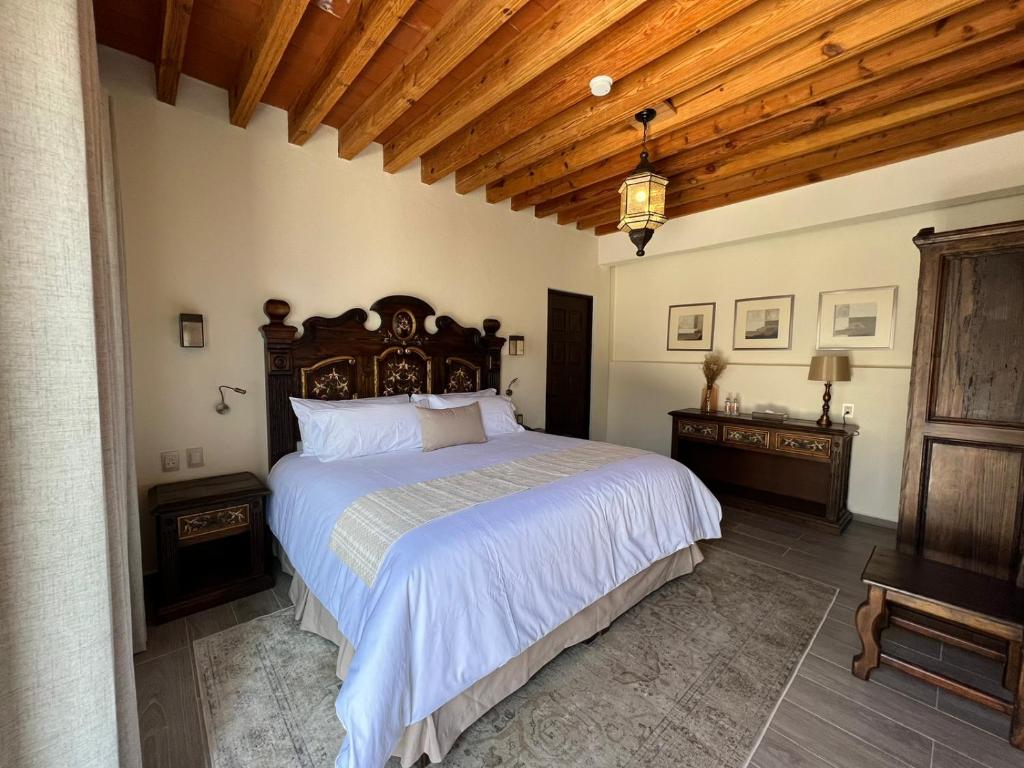 圣胡安德里奥Hotel Boutique Rincón de Luna的一间卧室设有一张大床和木制天花板