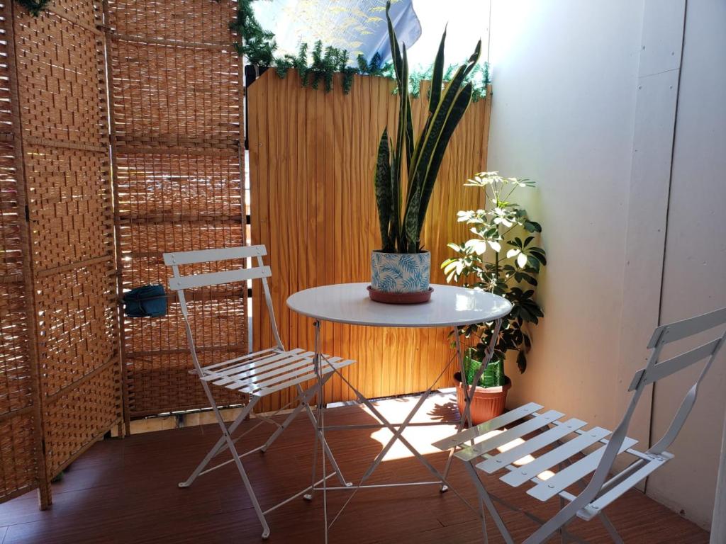 伊基克Un lugar encantador con una pequeña terraza的一张桌子,上面有两把椅子和盆栽植物