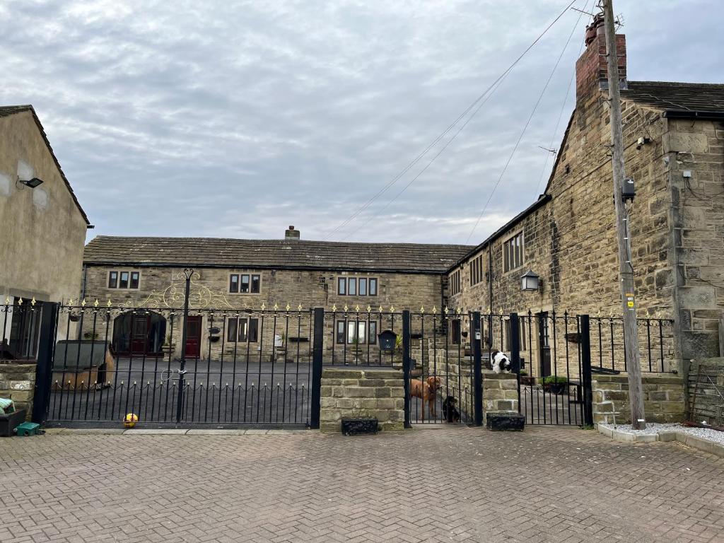 StanningleyThe Farm House Modern spacious 2 bedroom home at Tong road Leeds perfect for contractors free secure parking的一座古老的石头建筑,前面有一个门