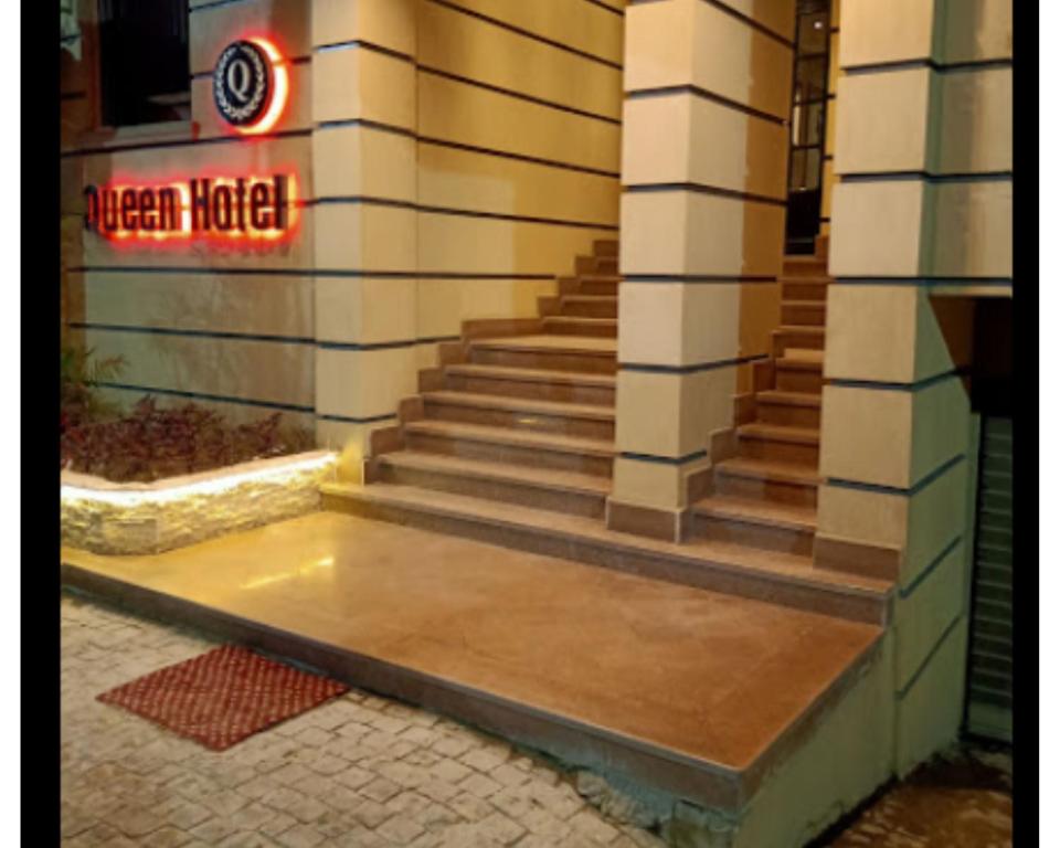 法尤姆Queen Hotel Fayoum的楼外有 ⁇ 虹灯标志的楼梯
