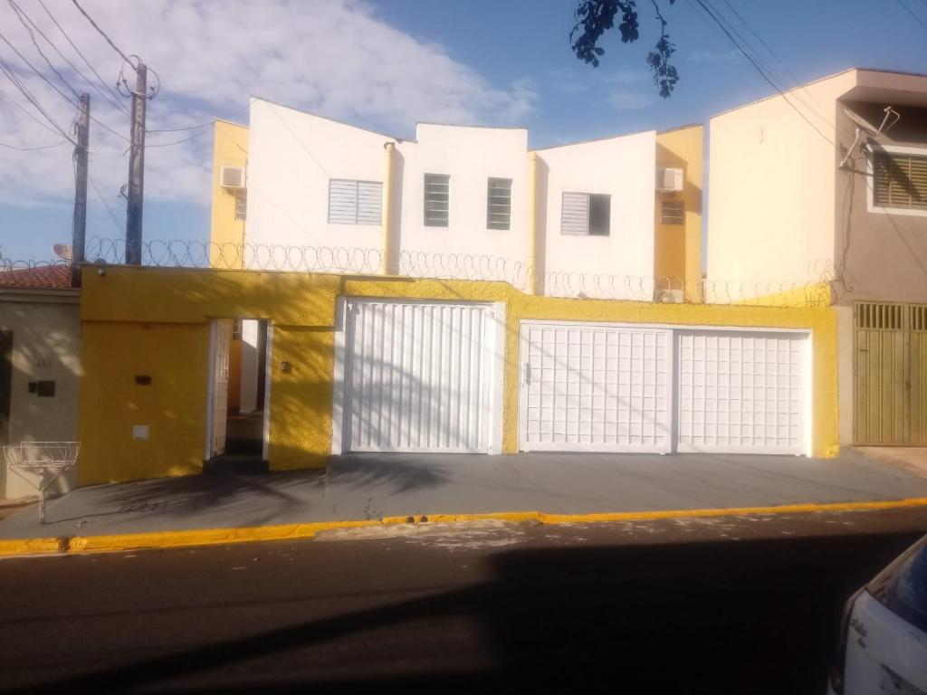 里贝朗普雷托Hostel Araucaria的白色和黄色的建筑,设有大门