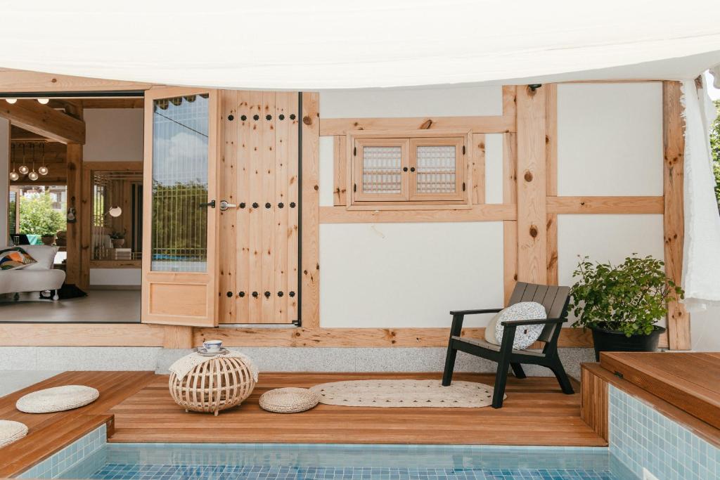 庆州Gyeongju Hanok Sohwa的一个带游泳池和门廊椅子的房子