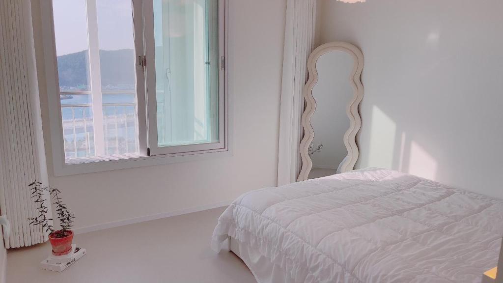 统营市Tongyeong Canal Ocean View的白色的卧室设有床和窗户