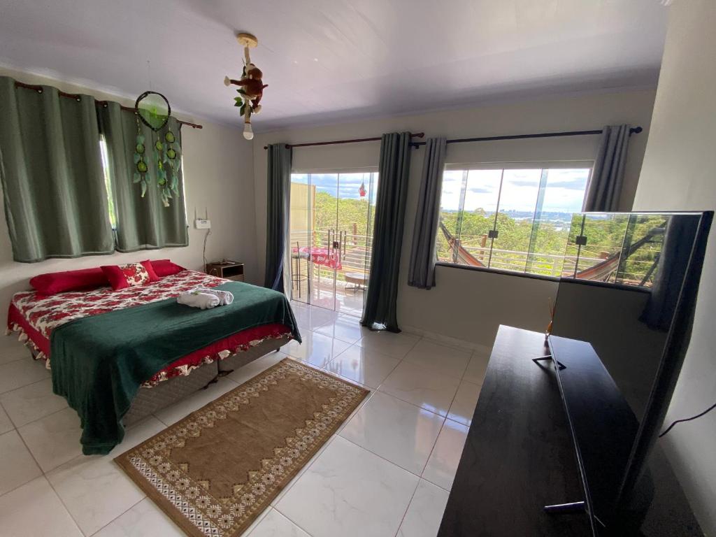 巴西利亚Sunshine Chalé Brasília-DF的一间卧室配有一张带红色枕头的床和一扇窗户