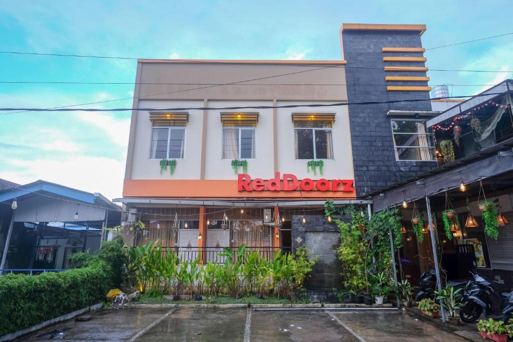 美娜多RedDoorz near Jalan Wolter Monginsidi Manado的大楼里一间有红色标志的餐厅