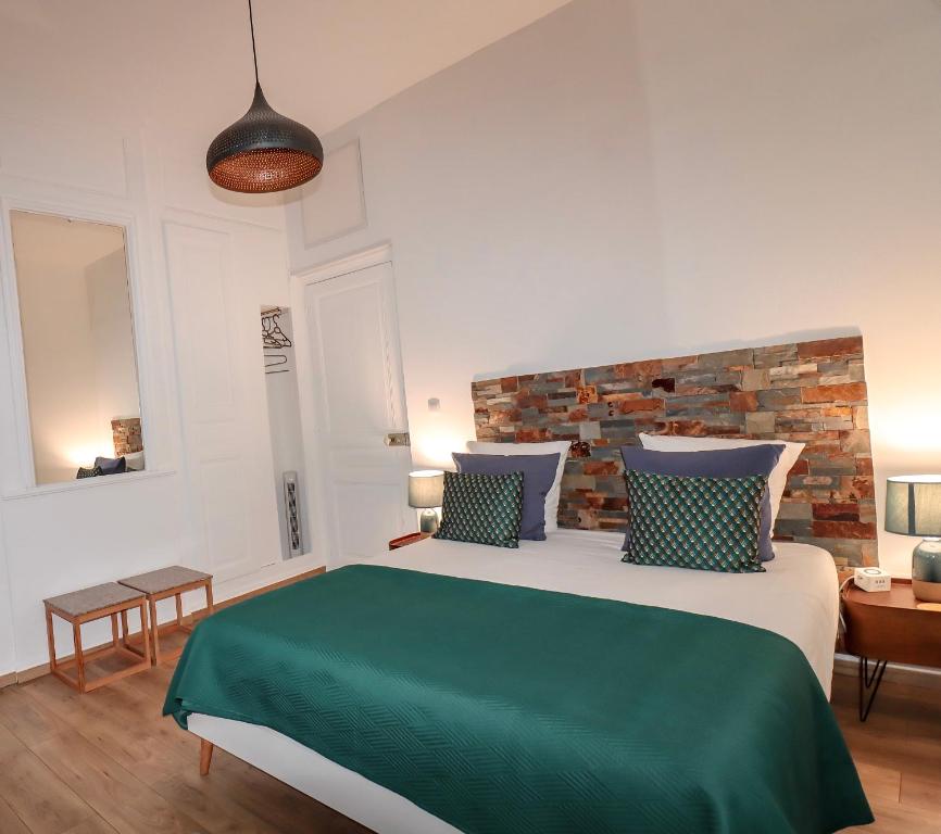 亚眠Ginkgo Maison d'hôtes的一间卧室设有一张带砖墙的大床