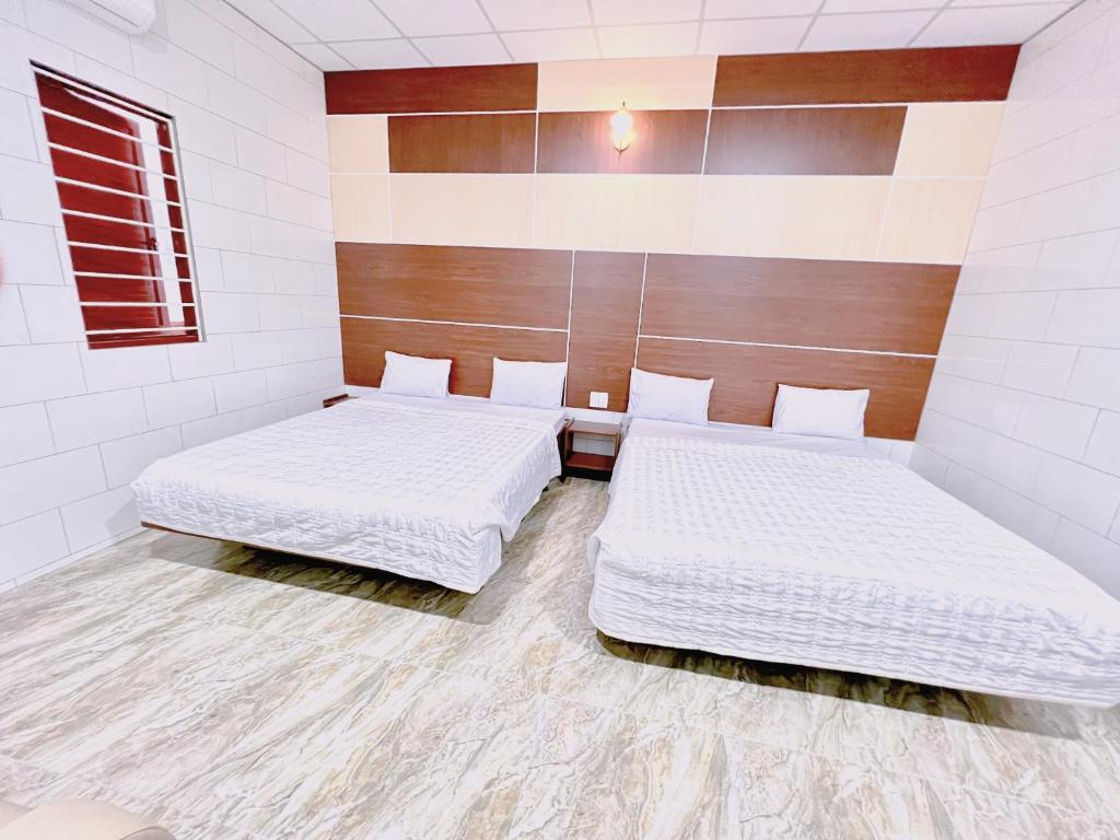 Thôn Tân HộiKhách sạn Ngọc Bích 2的白色墙壁客房的两张床