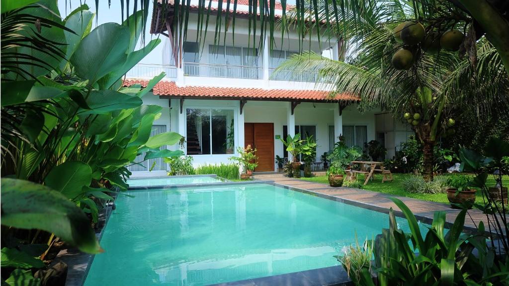 斯勒曼Villa Prambanan Jogja with Private Swimming Pool by Simply Homy的房屋前的游泳池