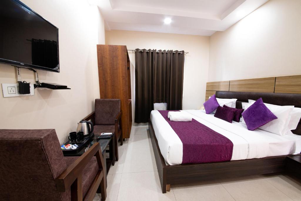 哈里瓦Perfect Stayz Dwarkesh - Hotel Near Haridwar Railway station的酒店客房,配有床和电视