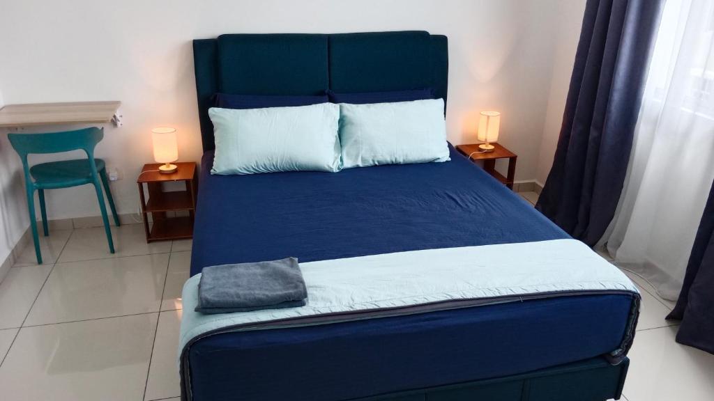 怡保Muslim Homestay at Meru Ipoh With Swimming Pool & Free Parkings的一间卧室配有蓝色的床和蓝色床头板