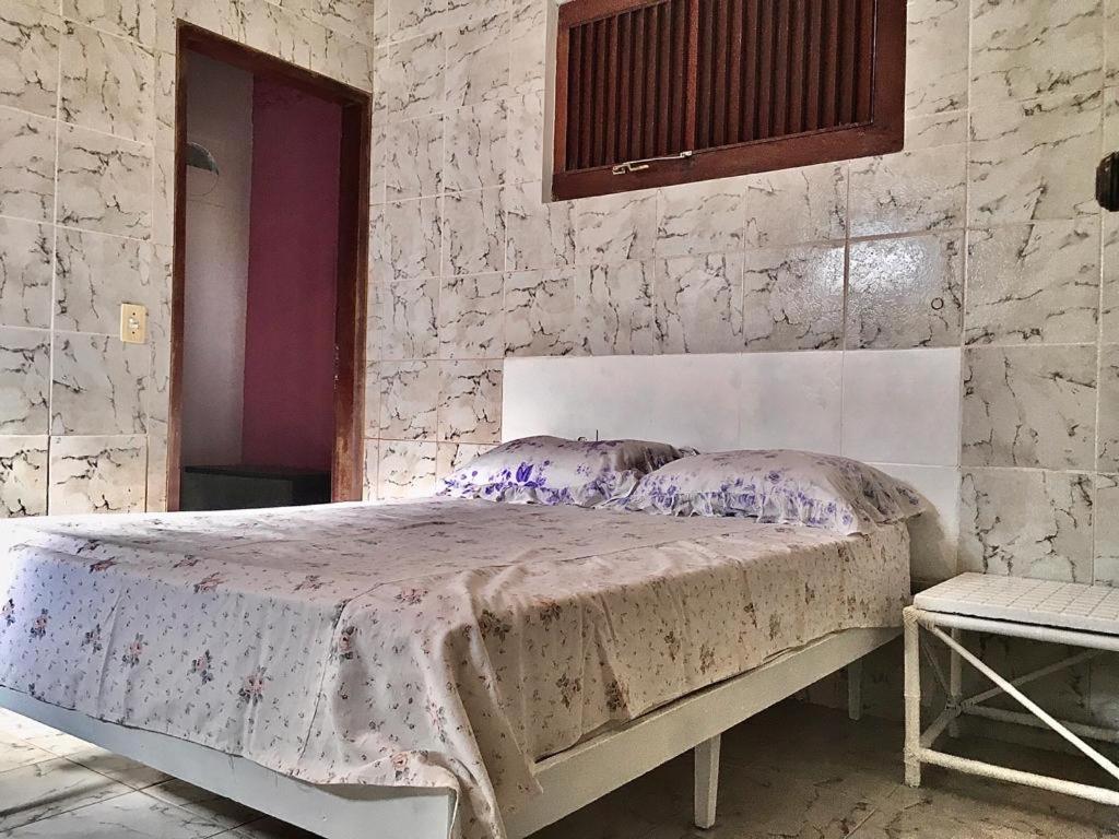 康德Falésias de Carapibus的卧室配有一张石墙床