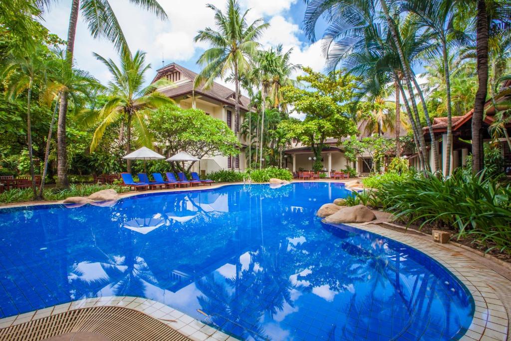 万象瑟塔宫酒店的棕榈树屋前的游泳池