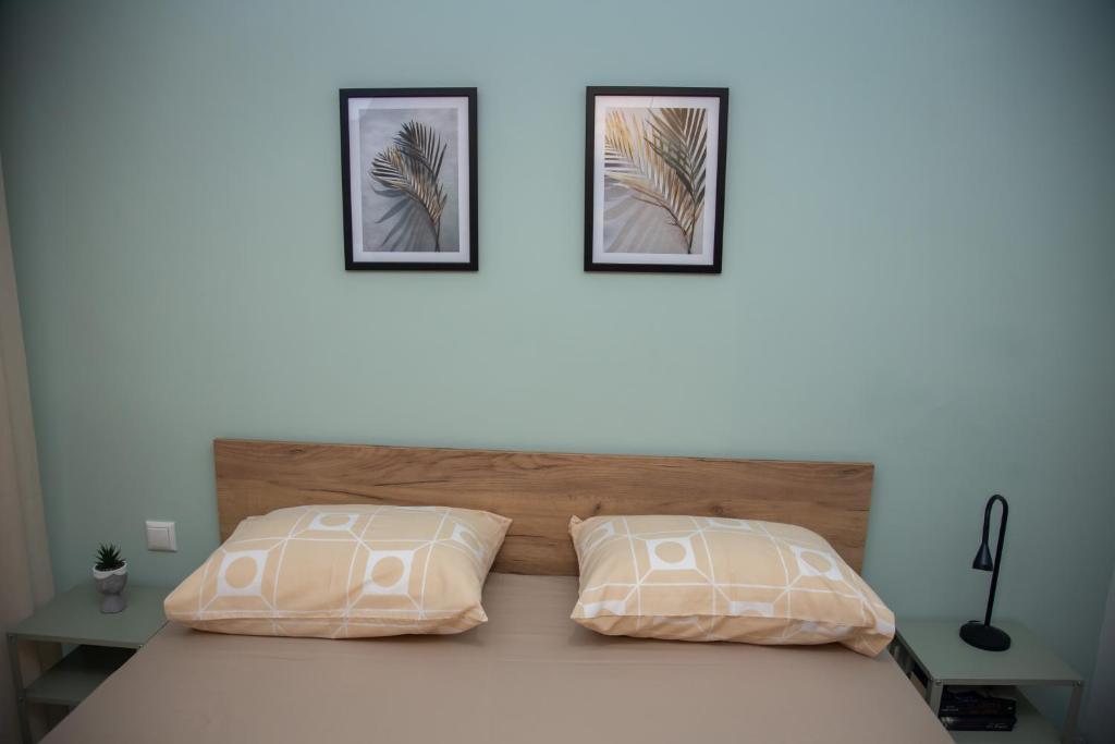 塞萨洛尼基Fobillo Apartment at Charilaou的卧室配有一张墙上有两张照片的床。