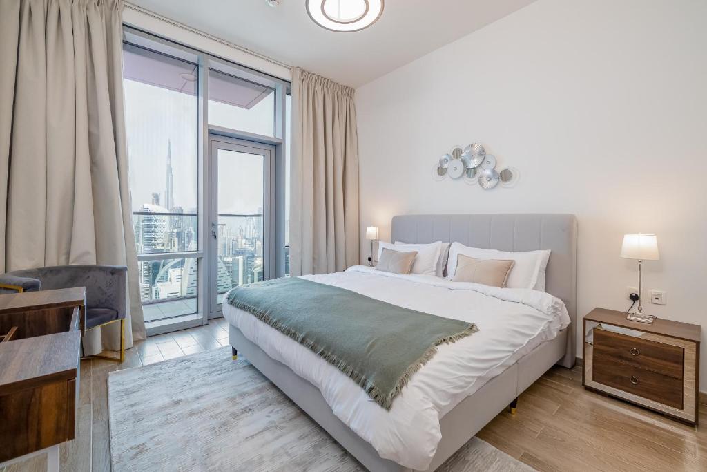 迪拜Spacious 3BDR Apartment and maid room with Burj Khalifa View的一间卧室设有一张大床和一个大窗户