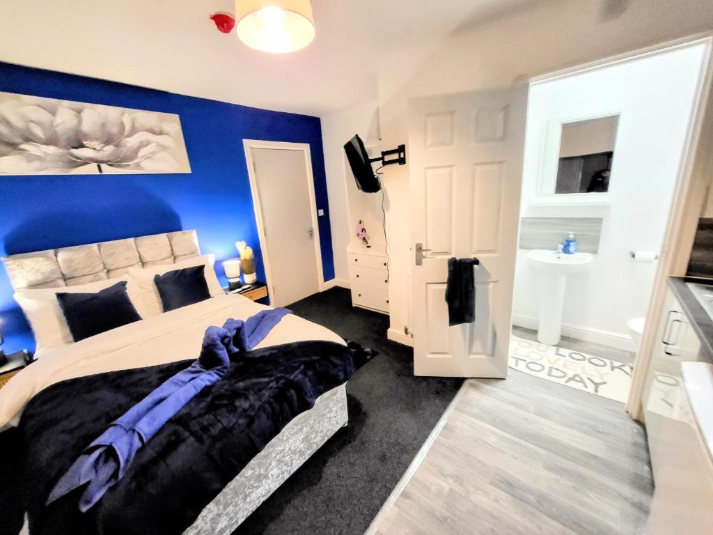 诺丁汉Burford Road - Stay. Sleep. Rest.的一间卧室设有一张蓝色墙壁的大床