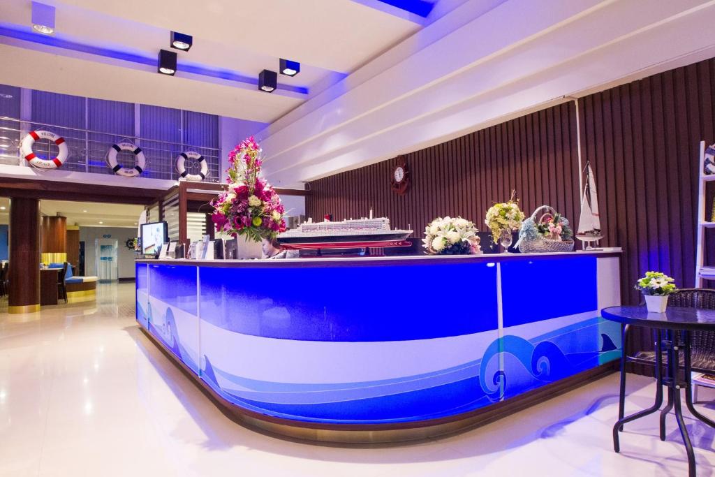 暖武里府Bed By Cruise Hotel At Samakkhi-Tivanont的大堂的蓝色和白色酒吧,鲜花盛开