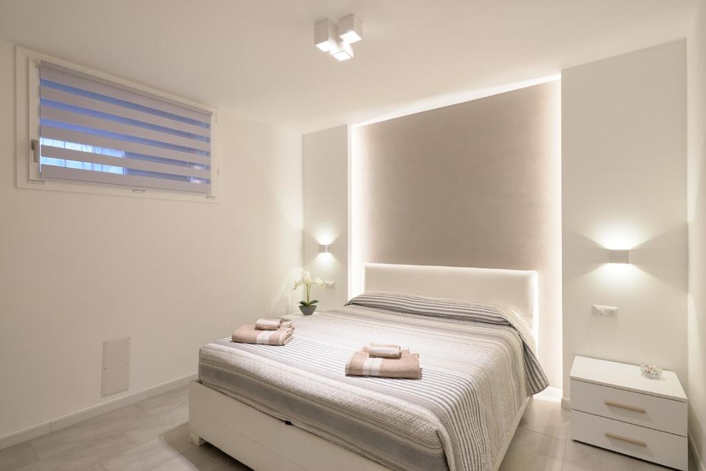 阿尔盖罗Corallo House Alghero的白色卧室配有带2条毛巾的床