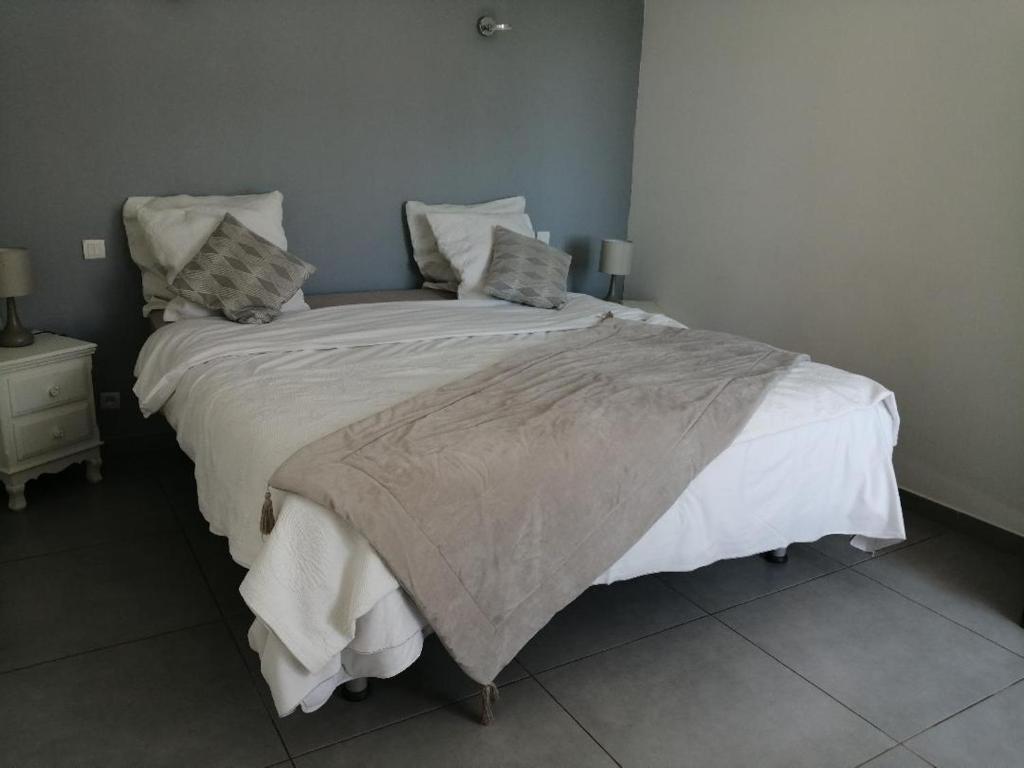 弗雷瑞斯Mimosas - villa的卧室配有一张带白色床单和枕头的大床。