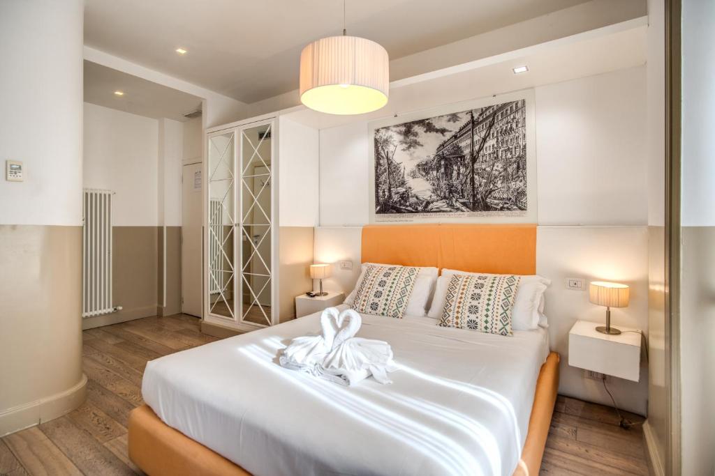 罗马罗马和平酒店的一间卧室配有一张白色大床,床上有鲜花