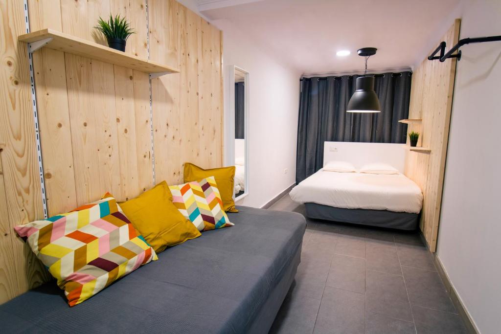 阿利坎特Koala Hostel的一间配有沙发和一张床的房间