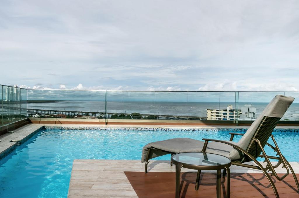 巴拿马城Boutique Apartments Panamá Coco del Mar的一个带椅子和桌子的游泳池