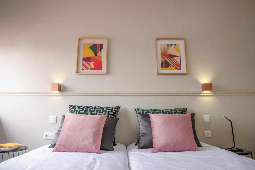 马亚Hotel Singular Porto Aeroporto的卧室配有两张床,墙上挂有两张照片