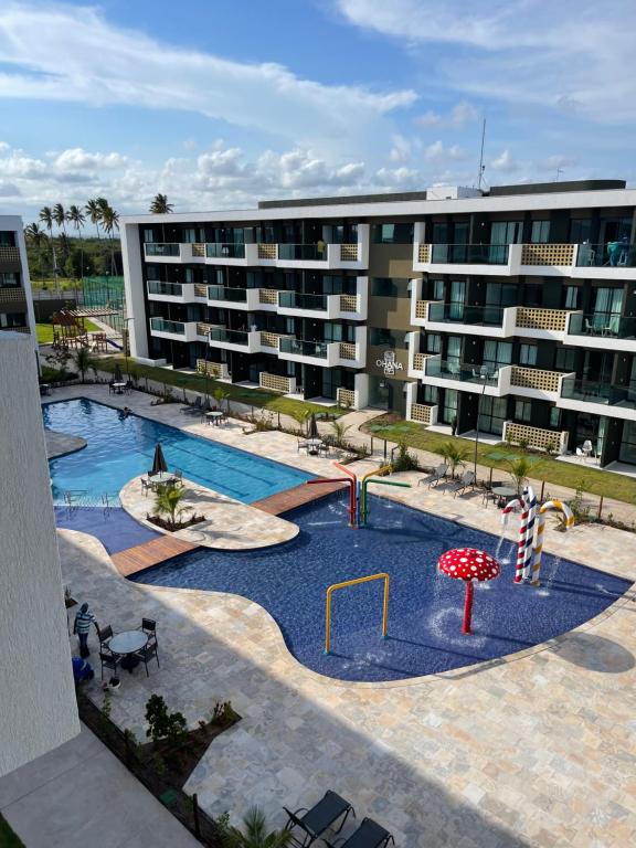 嘎林海斯港Mana Beach Experience - Muro Alto - Flat Luxo 2 qtos的一座大型公寓大楼,设有游泳池和游乐场