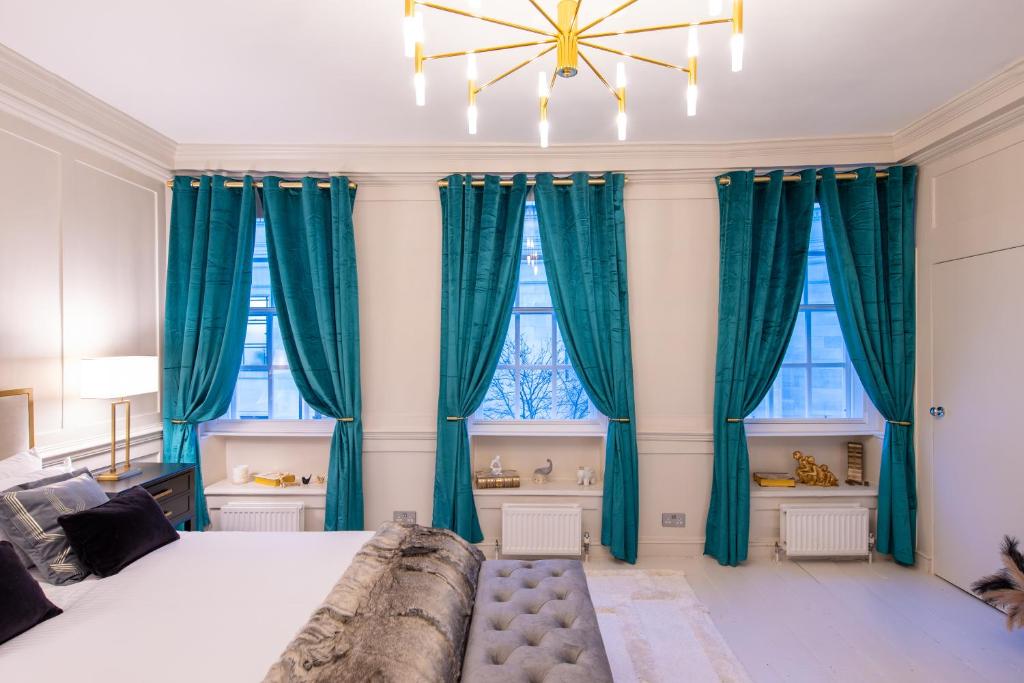 伦敦Haus of Mason的一间卧室配有蓝色窗帘和一张大床