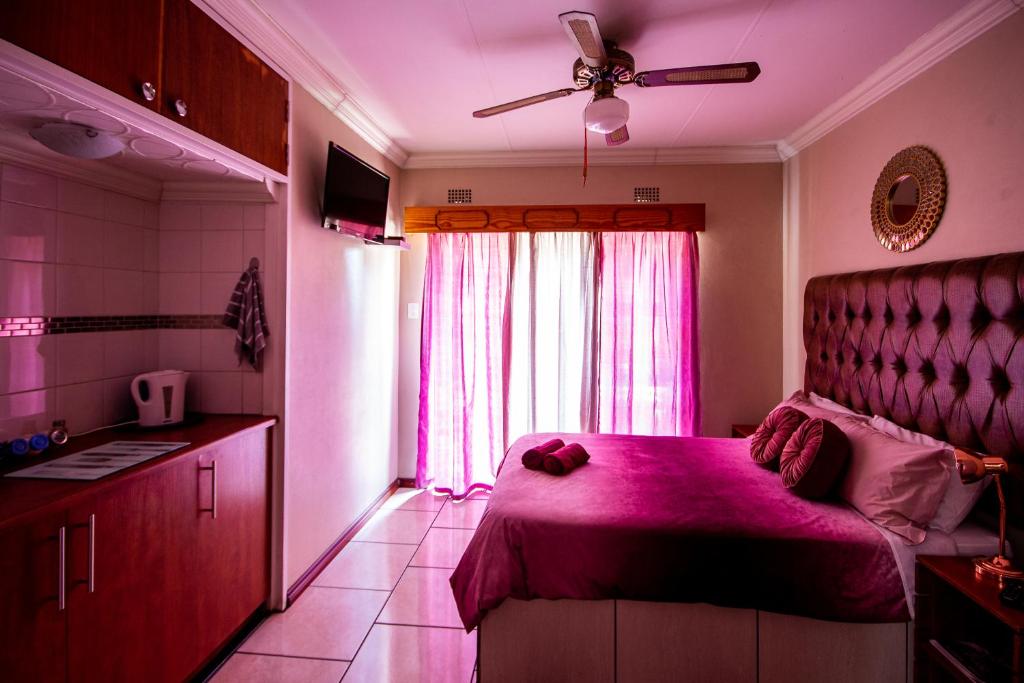 范德拜尔帕克Invite Guest House Self Catering Accommodation的卧室配有粉红色的床和窗户。