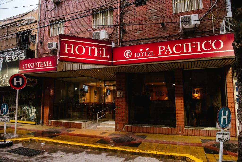 门多萨Hotel Pacífico的建筑前方有红色标志的酒店