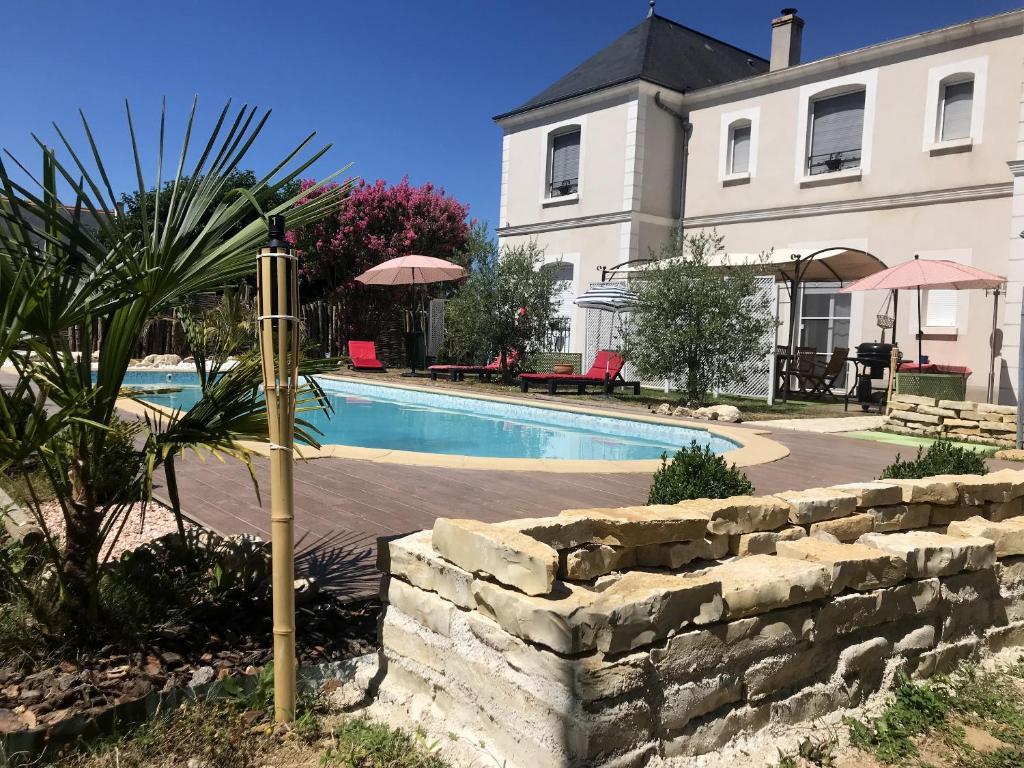 卢瓦尔河畔圣西Villa de 6 chambres avec piscine privee jardin clos et wifi a Saint Cyr sur Loire的房屋前的游泳池