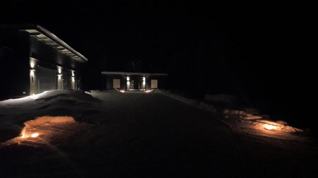 伊纳利Villa Paatari, Inari (Paadarjärvi)的黑暗的街道,晚上有建筑灯