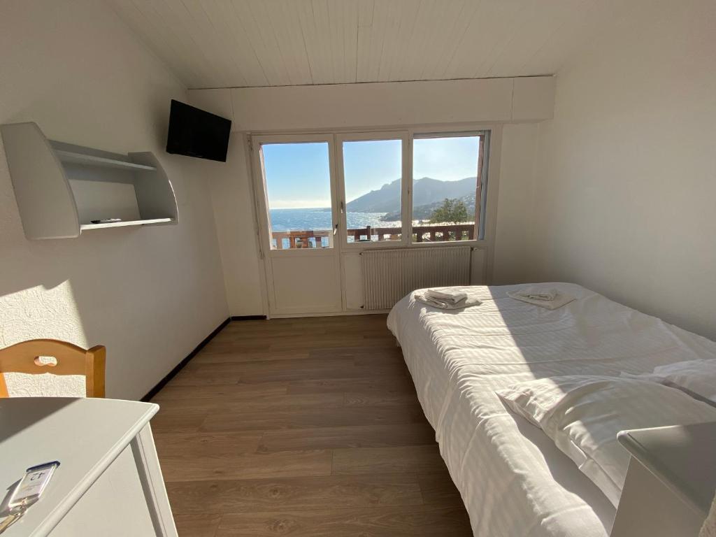 泰晤勒·苏尔·梅尔Village Vacances Lou Castelet的一间卧室设有一张床和一个大窗户
